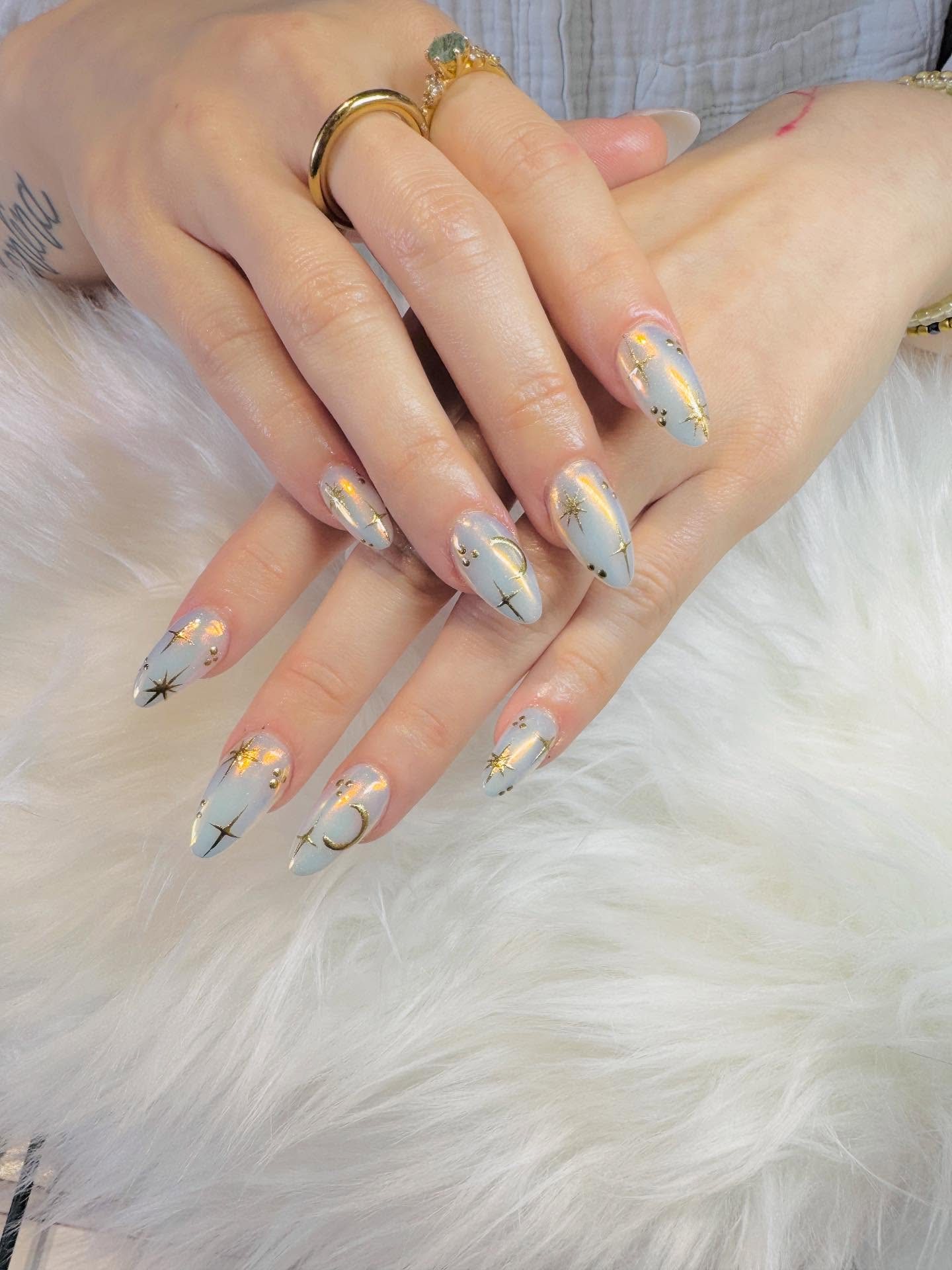 Grijsblauwe amandelnagels met gouden sterretjes