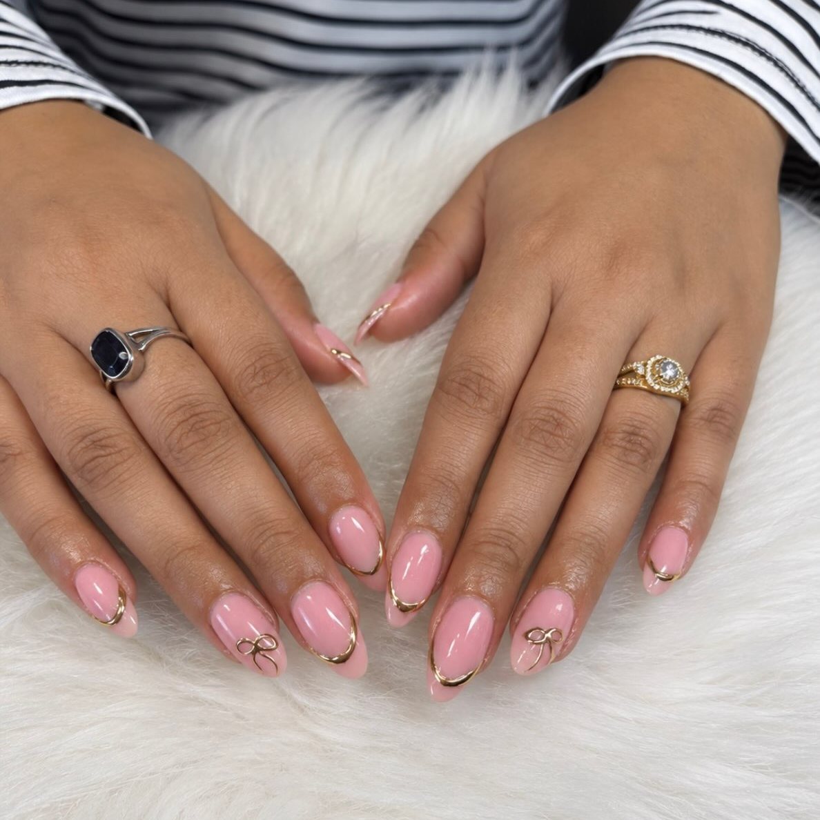 Roze amandelnagels met gouden randjes en strikjes