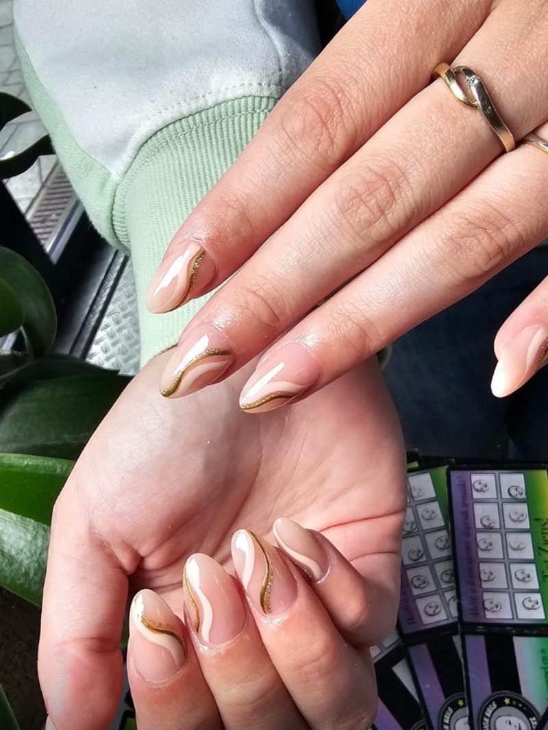 Nude nagels met dunne gouden swirls